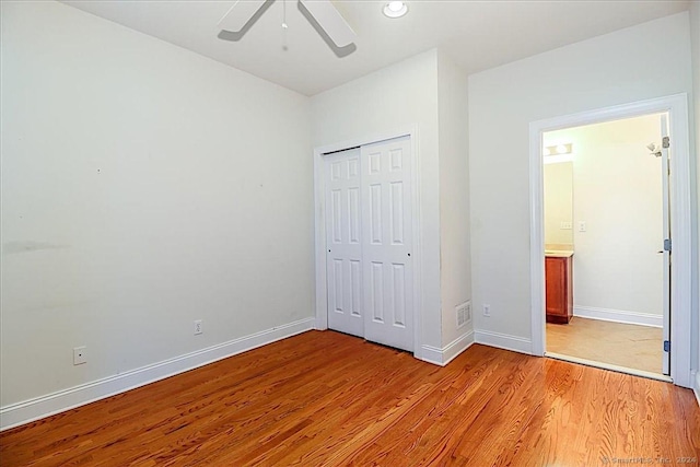 unfurnished bedroom with ceiling fan, a closet, and light hardwood / wood-style flooring