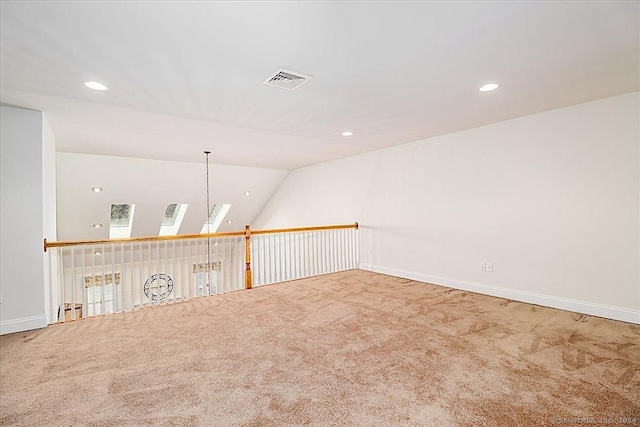 carpeted spare room with vaulted ceiling