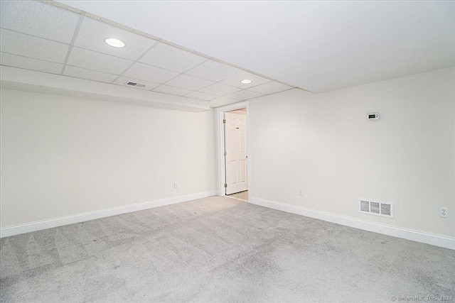 unfurnished room with a drop ceiling and light colored carpet