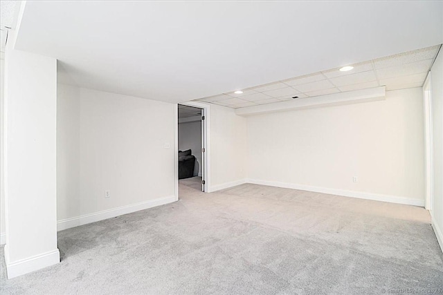 spare room featuring light carpet and a drop ceiling