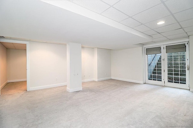 basement featuring light colored carpet and a drop ceiling