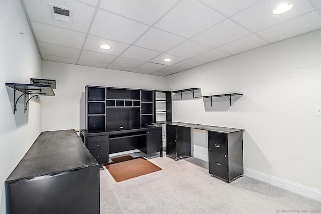 carpeted home office with a drop ceiling