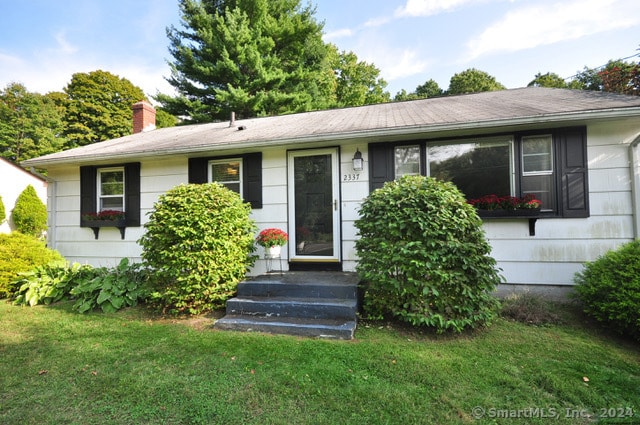 ranch-style home featuring a front lawn