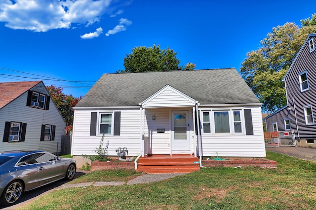 bungalow-style house featuring cooling unit and a front yard