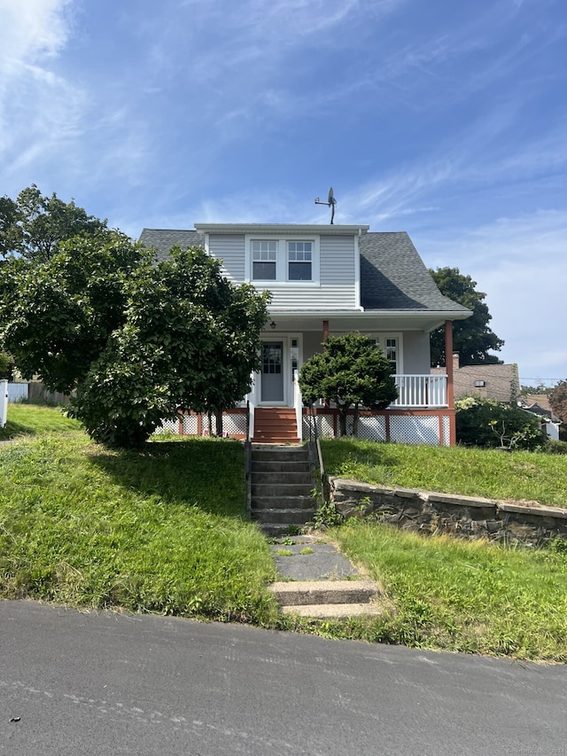 view of front of house with a front yard and covered porch