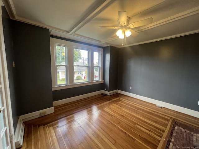 spare room featuring ceiling fan, hardwood / wood-style flooring, and crown molding