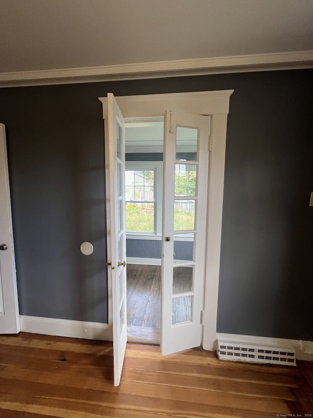 doorway with baseboard heating, hardwood / wood-style floors, and french doors