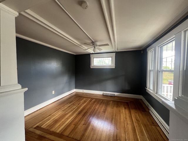 spare room featuring wood-type flooring, a baseboard radiator, ornamental molding, and a wealth of natural light