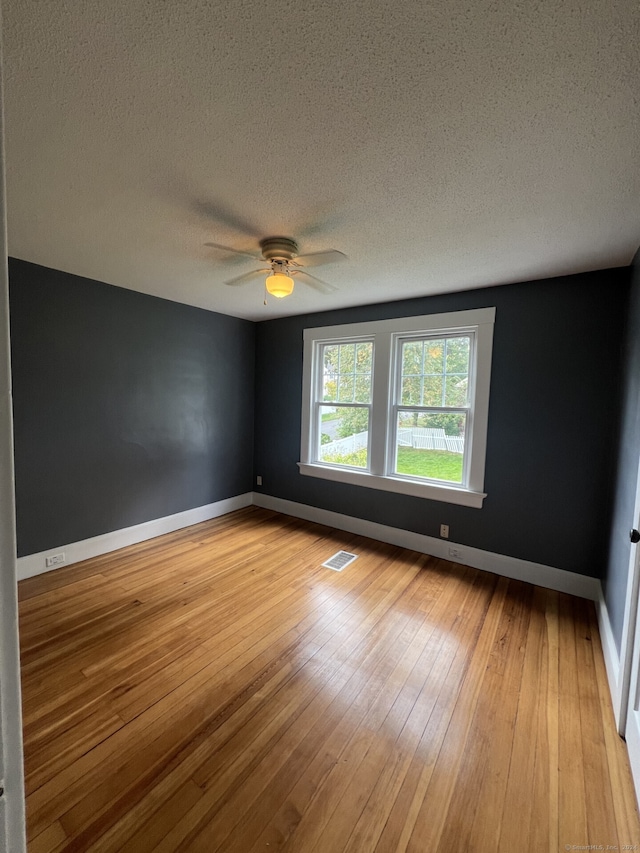 spare room with light hardwood / wood-style flooring, a textured ceiling, and ceiling fan