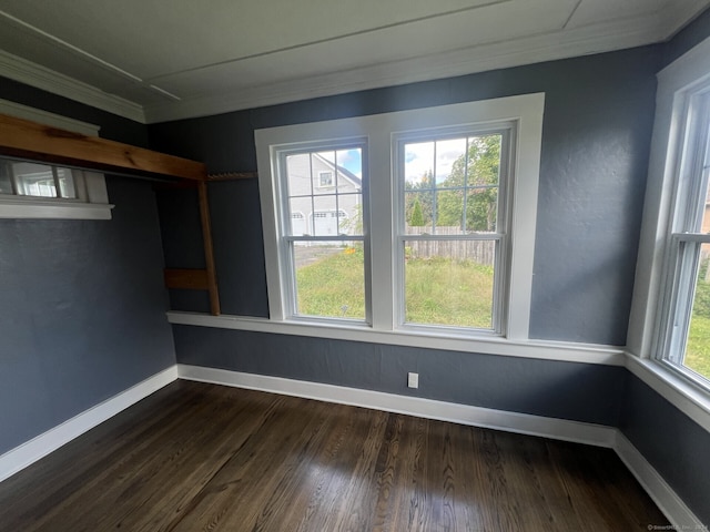 spare room with ornamental molding and dark wood-type flooring