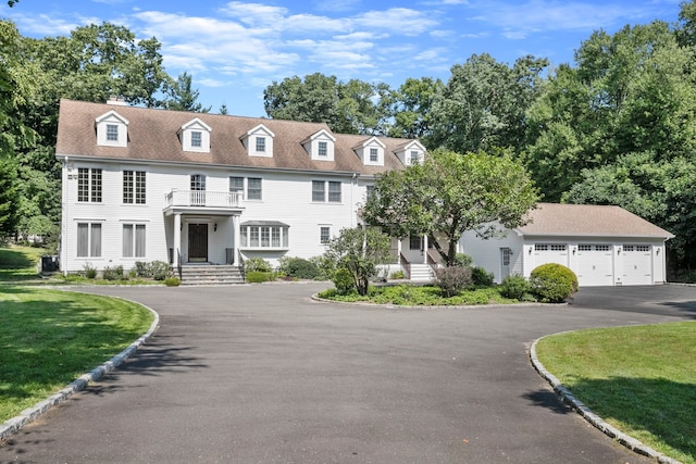 colonial home with a front yard, cooling unit, and a garage