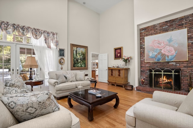 living room featuring a brick fireplace, french doors, hardwood / wood-style floors, and high vaulted ceiling