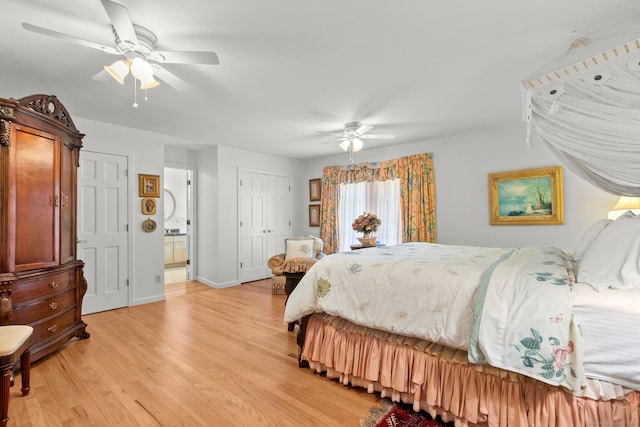 bedroom with light hardwood / wood-style flooring, ensuite bath, and ceiling fan