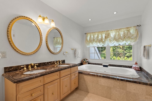 bathroom featuring tile patterned flooring, tiled tub, and vanity