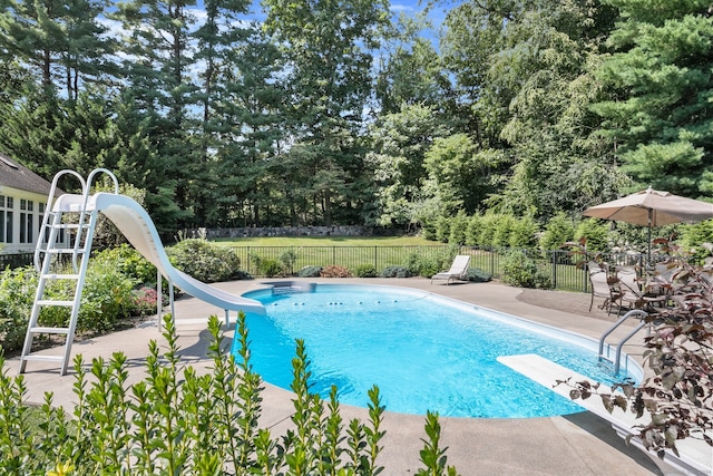 view of swimming pool featuring a patio, a water slide, and a diving board