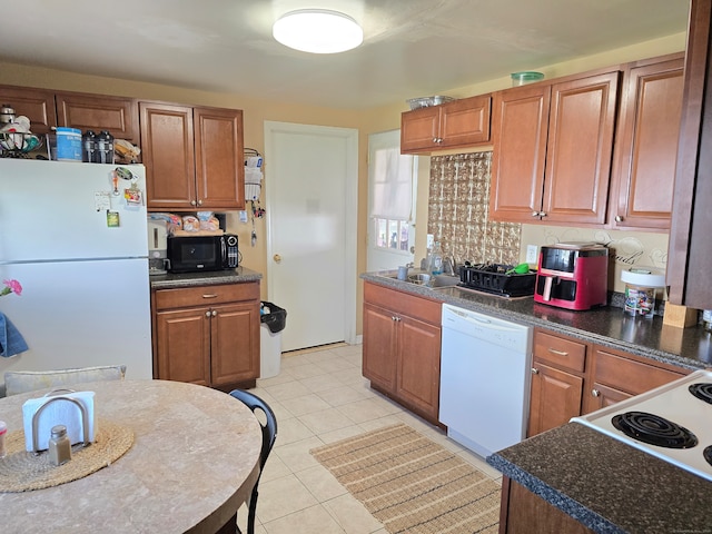 kitchen with sink, light tile patterned floors, and white appliances