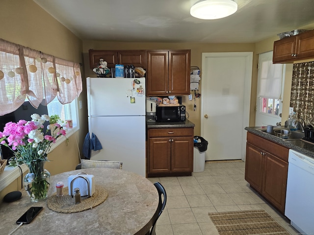 kitchen featuring white appliances, light tile patterned floors, and sink