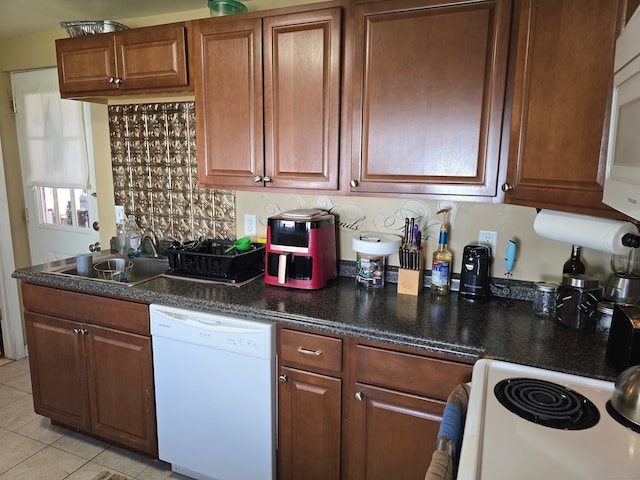 kitchen with white appliances, sink, and light tile patterned floors