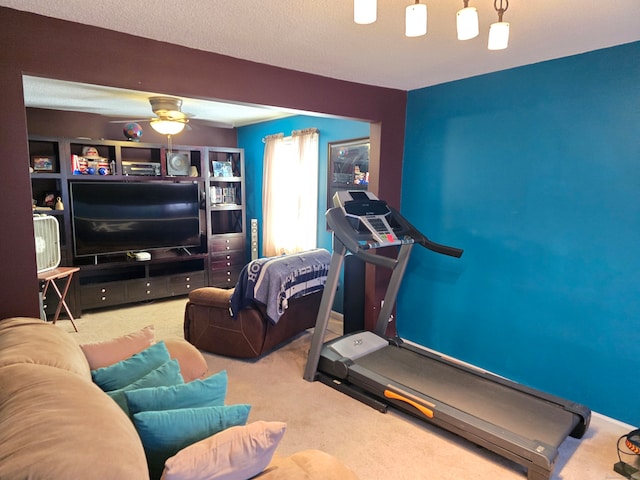 workout area featuring a textured ceiling, carpet flooring, and ceiling fan