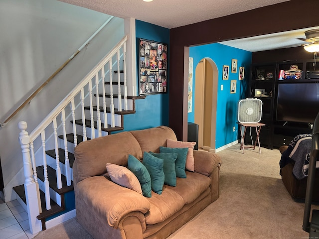 living room with a textured ceiling, carpet, and ceiling fan