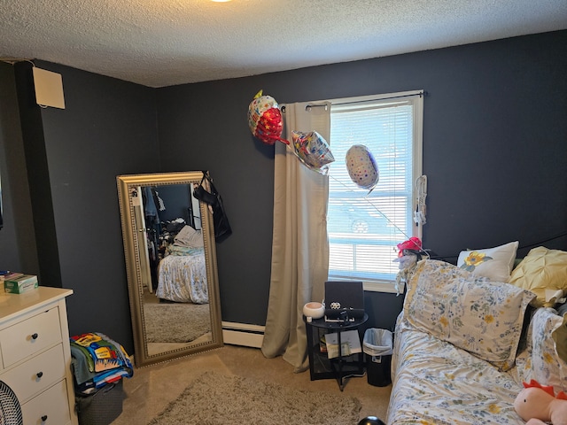 carpeted bedroom featuring a textured ceiling and a baseboard heating unit