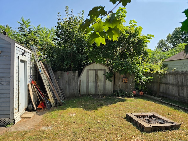 view of yard featuring a fire pit and a storage shed