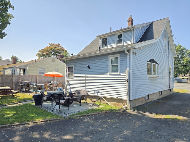 rear view of house with central AC and a patio area