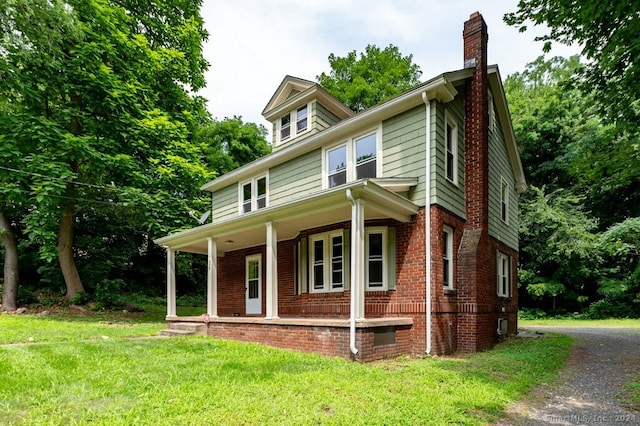 view of front facade with a front yard and covered porch