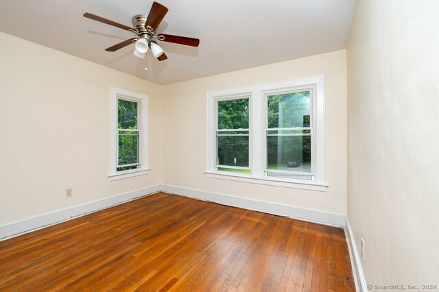 empty room with ceiling fan and hardwood / wood-style flooring