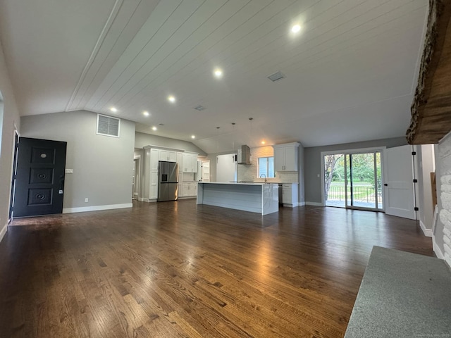 unfurnished living room featuring a fireplace, vaulted ceiling, and dark wood-type flooring