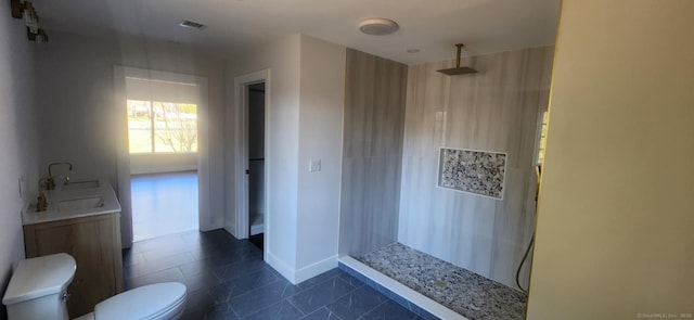 bathroom featuring tile patterned flooring, vanity, toilet, and walk in shower