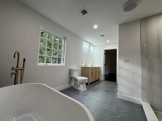 bathroom with vanity, a tub to relax in, and toilet