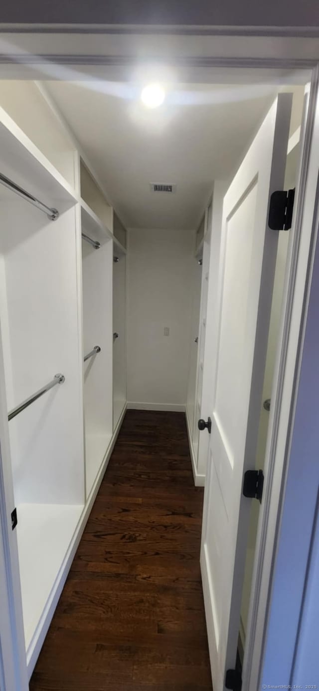 spacious closet with dark hardwood / wood-style flooring