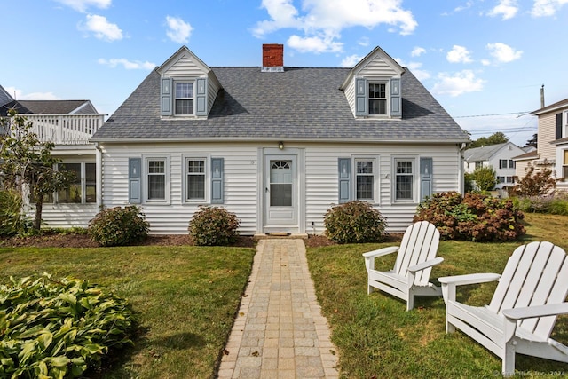 cape cod home featuring a front lawn