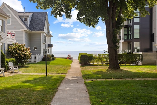 surrounding community with a lawn and a water view