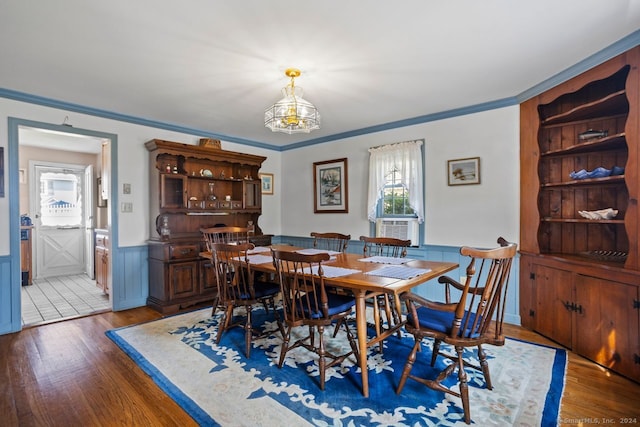 dining room with hardwood / wood-style flooring, plenty of natural light, a chandelier, and crown molding