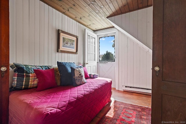 bedroom featuring wood-type flooring, wood ceiling, wood walls, and baseboard heating