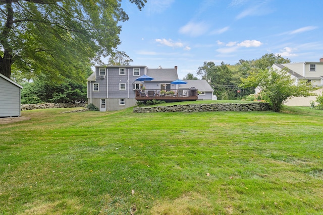 rear view of house featuring a wooden deck and a yard