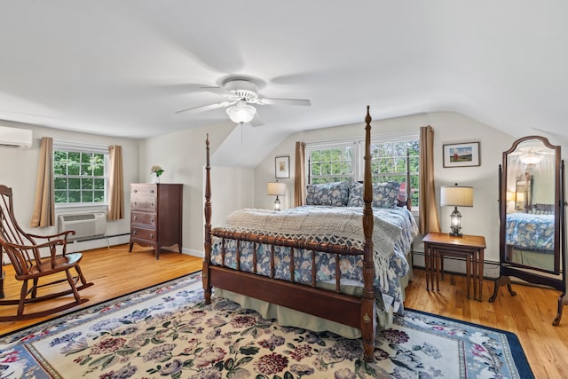 bedroom featuring ceiling fan, hardwood / wood-style floors, a wall mounted AC, a baseboard radiator, and vaulted ceiling