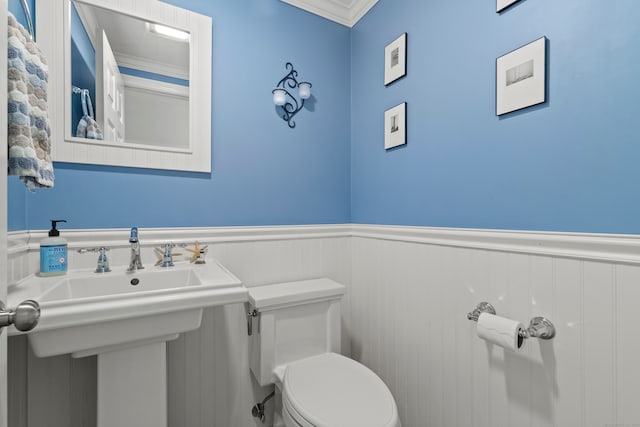 bathroom with ornamental molding and toilet