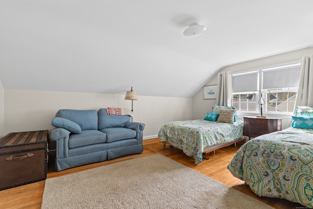 bedroom with light wood-type flooring and lofted ceiling