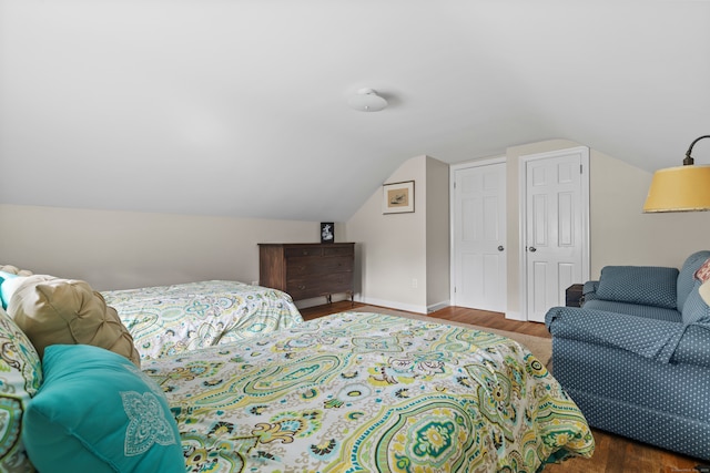 bedroom featuring vaulted ceiling and dark wood-type flooring