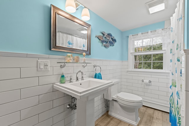 bathroom featuring tile walls, hardwood / wood-style flooring, and toilet