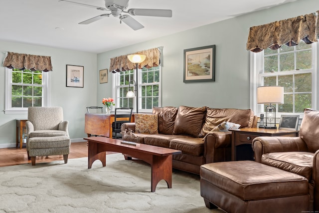 living room with light wood-type flooring, ceiling fan, and a healthy amount of sunlight