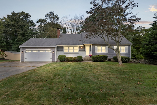 view of front facade featuring a garage and a lawn