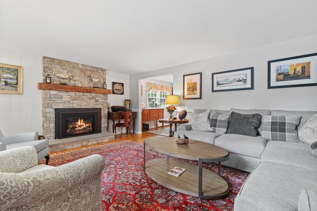 living room featuring hardwood / wood-style flooring and a stone fireplace