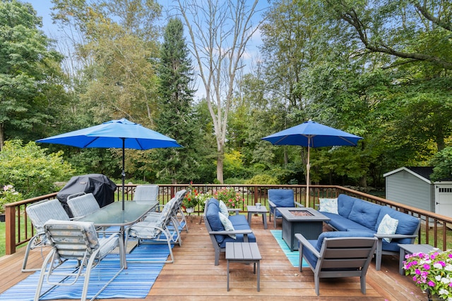 deck featuring a storage unit, grilling area, and an outdoor living space with a fire pit