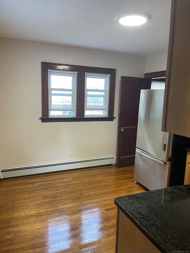 kitchen with light hardwood / wood-style flooring, stainless steel fridge, and baseboard heating