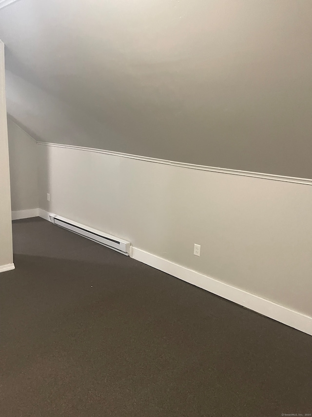 additional living space with vaulted ceiling and a baseboard radiator