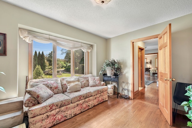 living room with light wood-type flooring and a textured ceiling